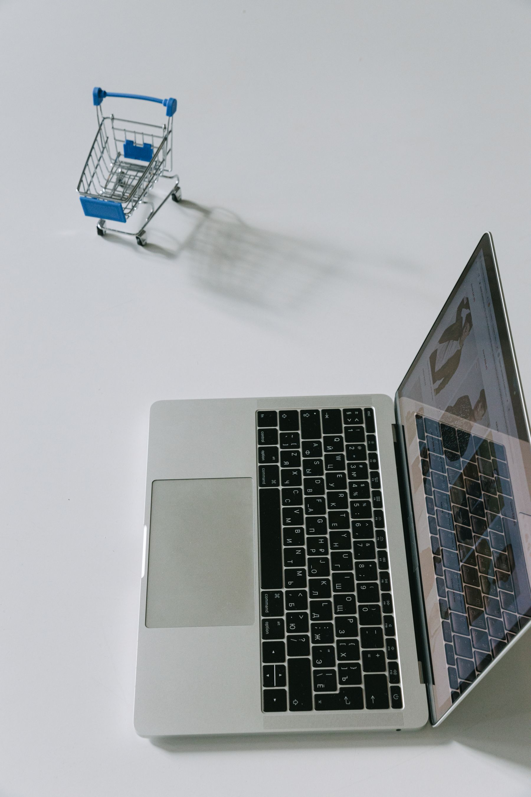 Laptop beside a miniature shopping cart, representing a DTC ecommerce journey